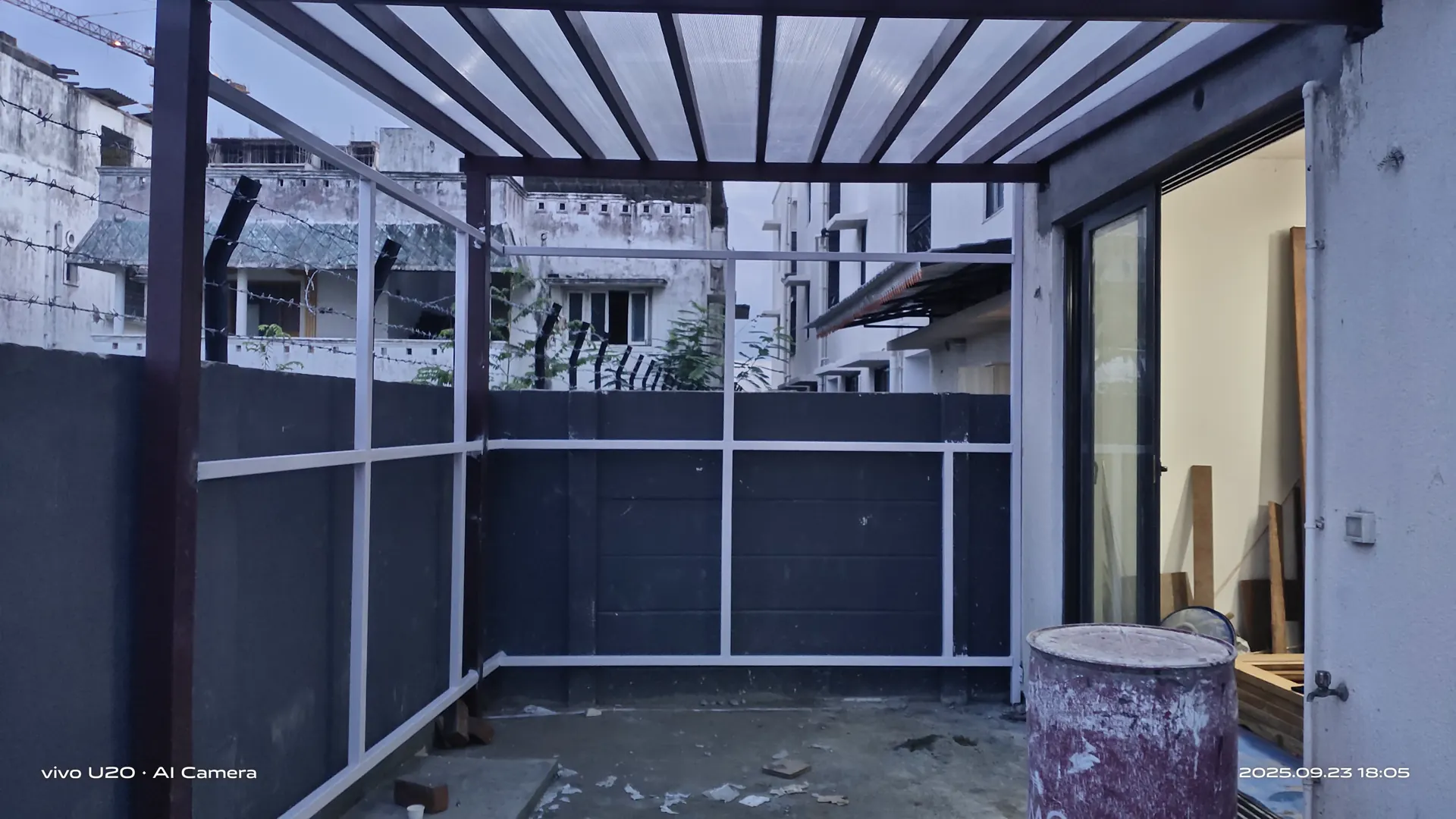 Light-transmitting roof and metal frame alongside a building during installation